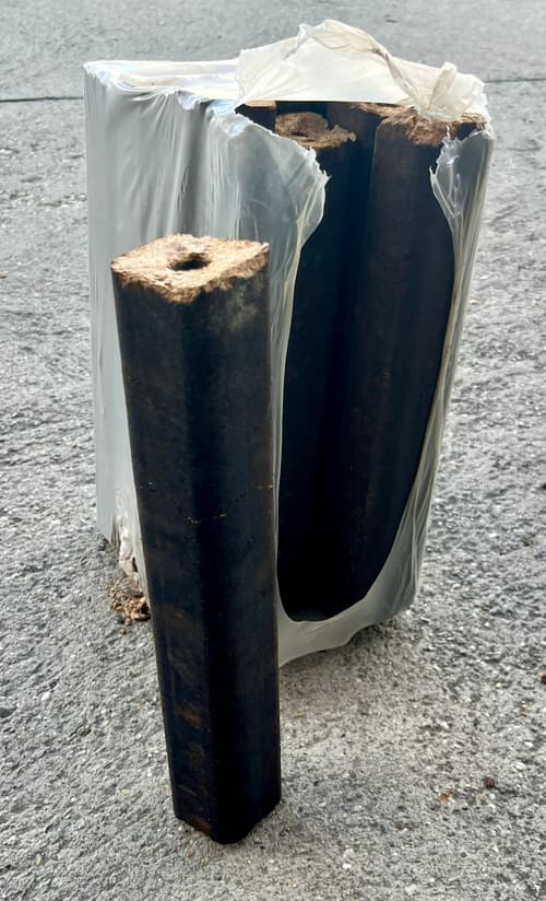 Pini-Kay keményfa brikett I. osztály – egy darab keményfa brikett és egy 10 kg-os csomag egymás mellett